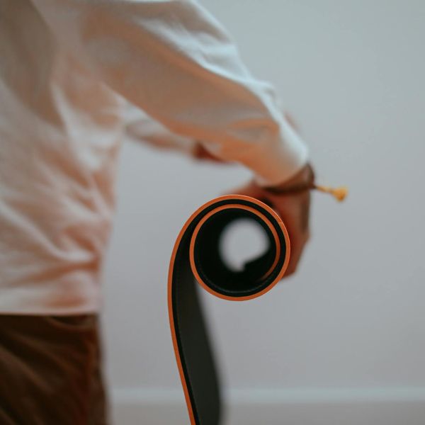 Person stretching on a yoga mat with a look of serene focus.